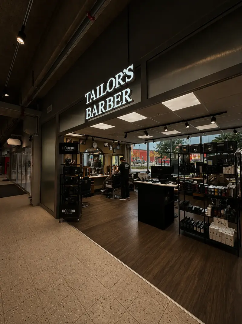 Ingången till Tailor's Barber Arninge med upplyst skylt