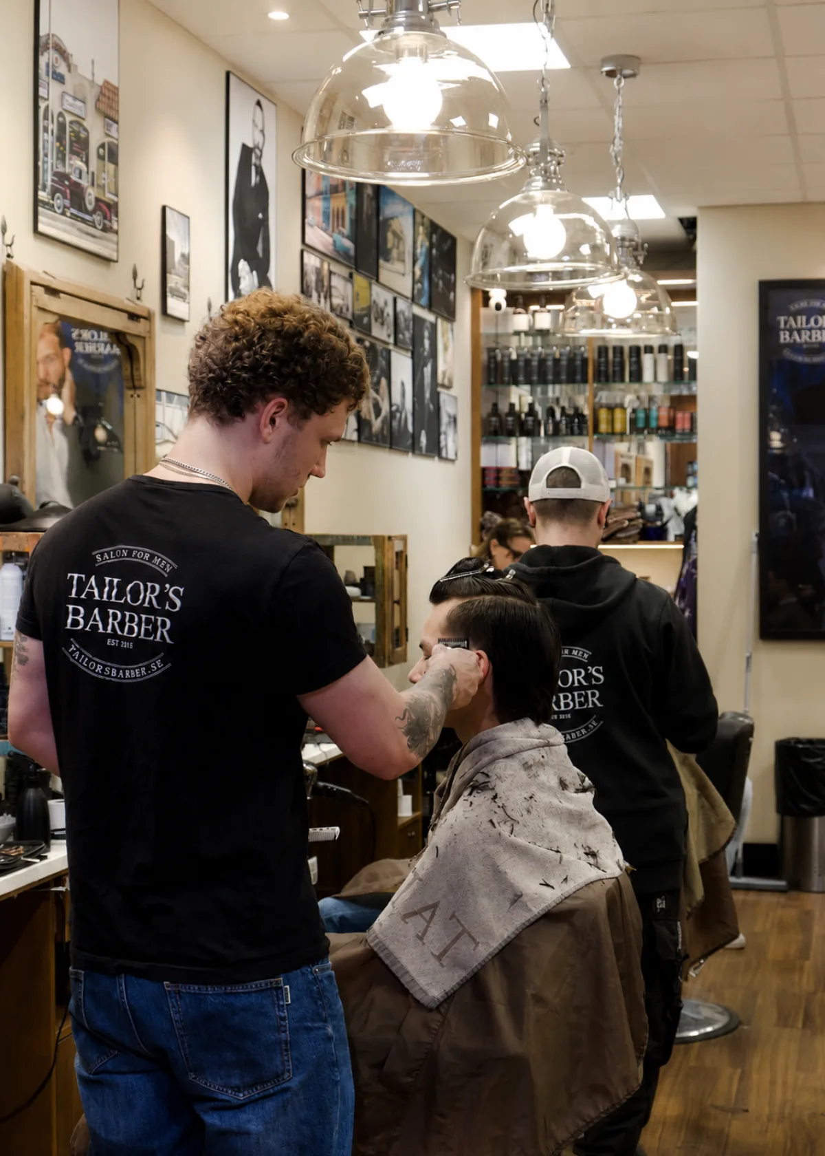 Barberare hos Tailor's Barber klipper en kund i salongen i Stockholm
