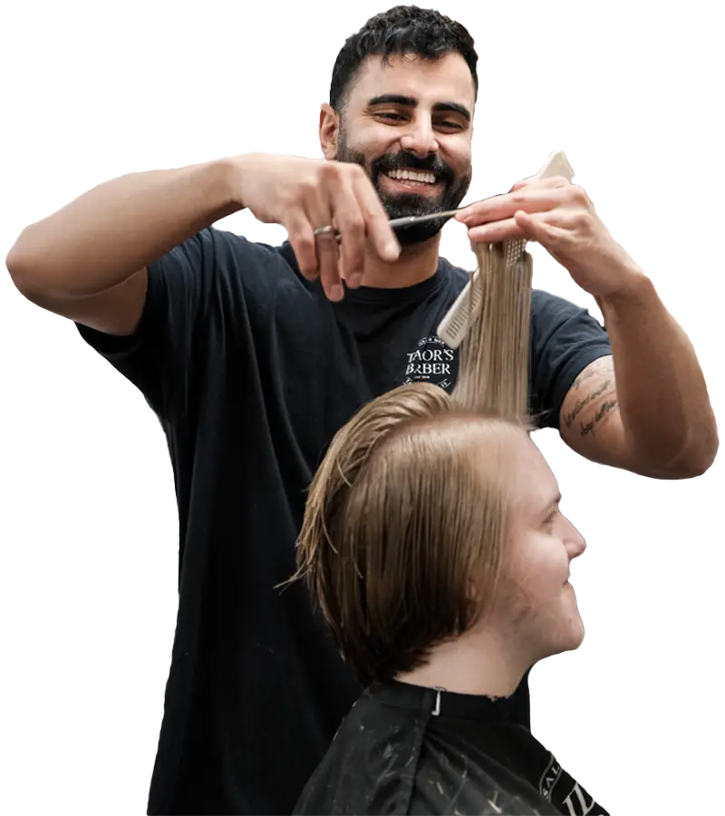 barber i stockholm som är glad medans hans klipper sin kunds hår med sax för en herrklippning.