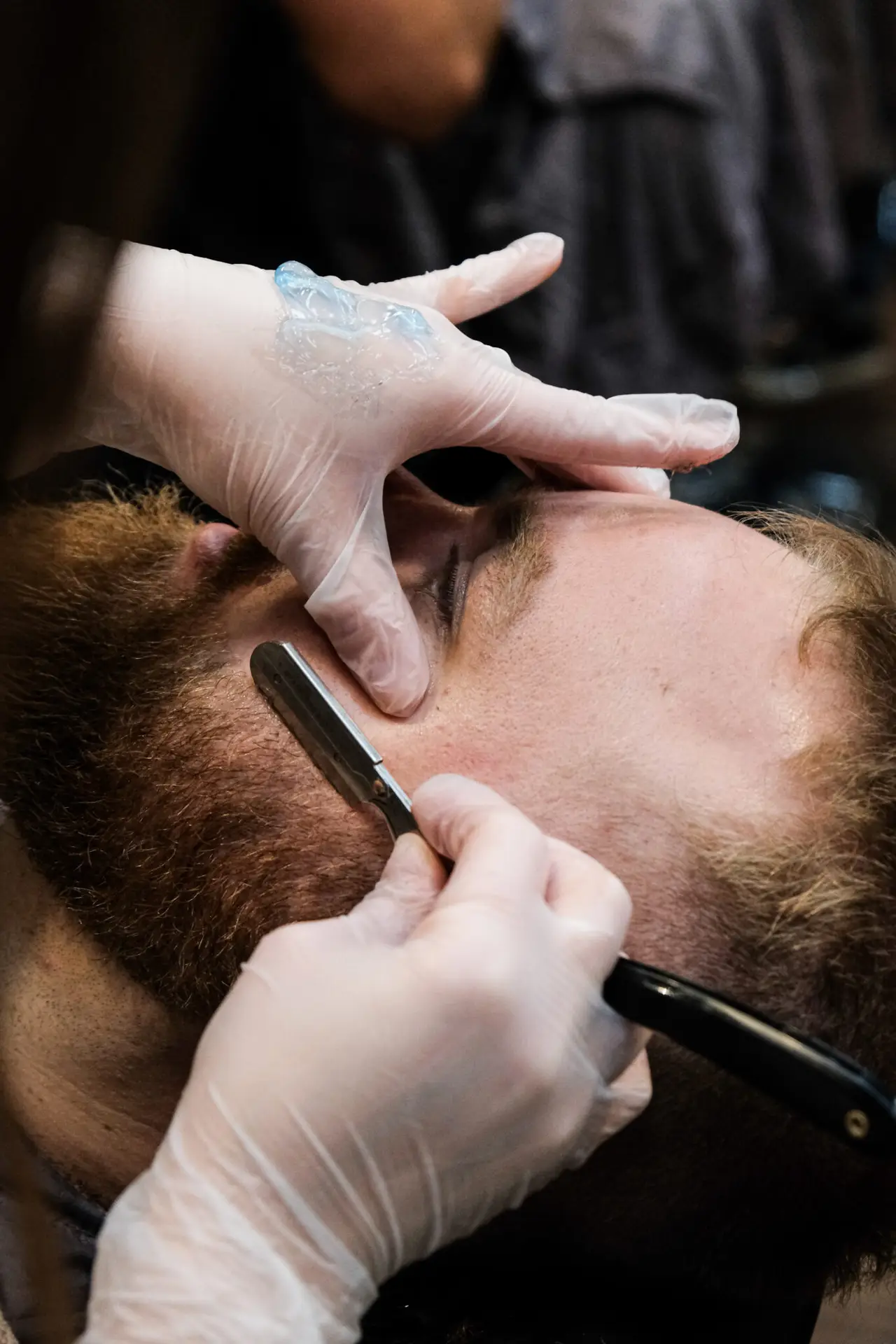 mans om får sitt skägg behandlat med kniv hos barberare i stockholm