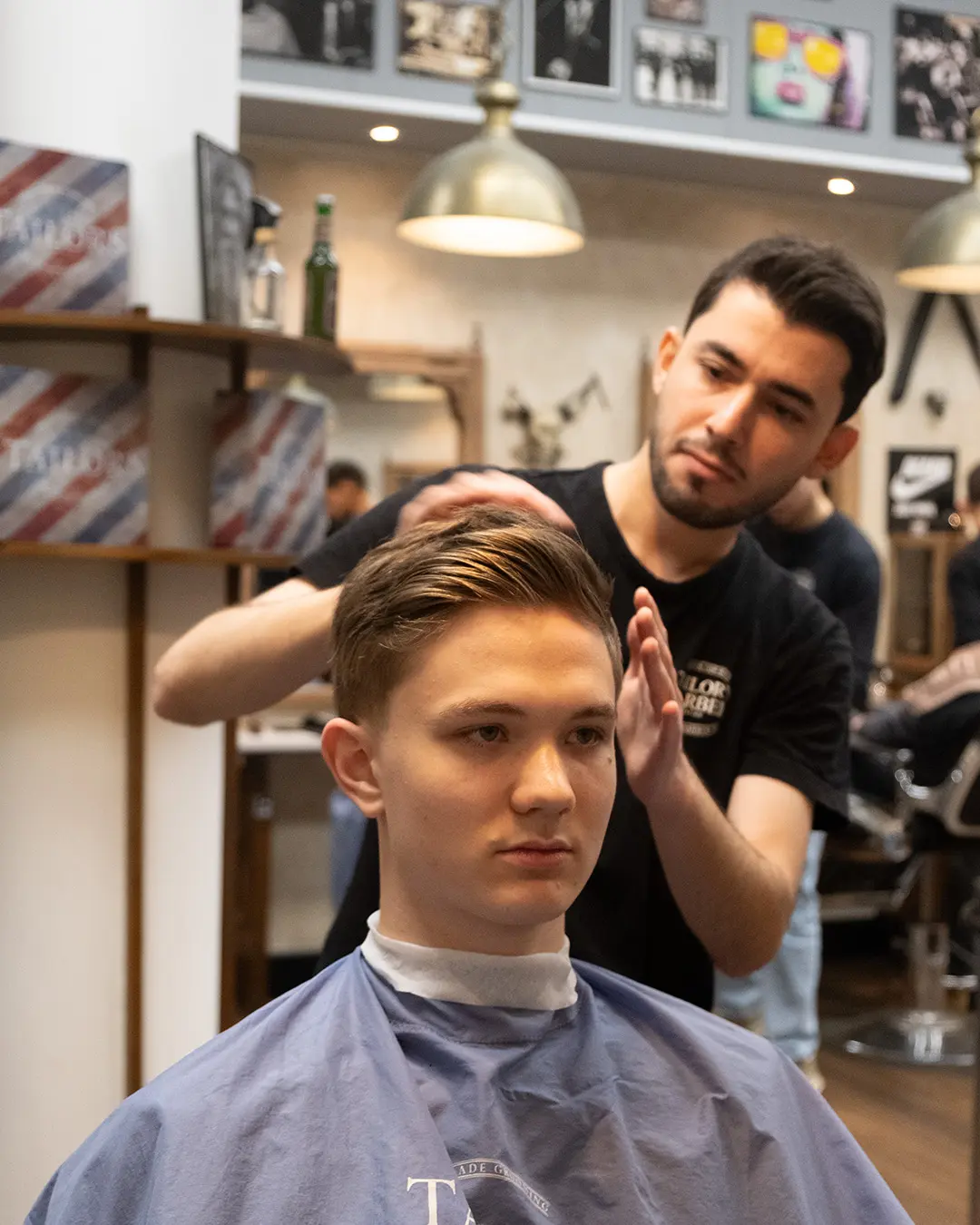 barberare stylar en annan killes hår.