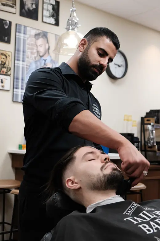 Barberare på Tailor’s Barber Åhléns City som trimmar och formar skägg