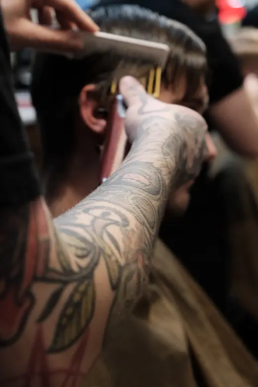 Barberare använder trimmer för herrklippning på Tailor’s Barber i Stockholm.
