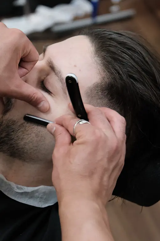 Traditionell rakning med rakkniv utförd av barberare på Tailor’s Barber i Stockholm.