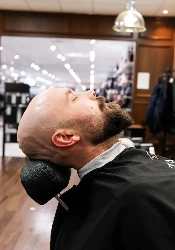 Kund får professionell skäggtrimning hos Tailor’s Barber i Stockholm.