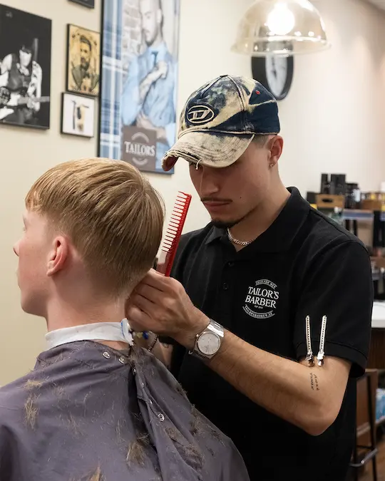 Bild på barber som klipper yngre man med maskin i täby centrum.