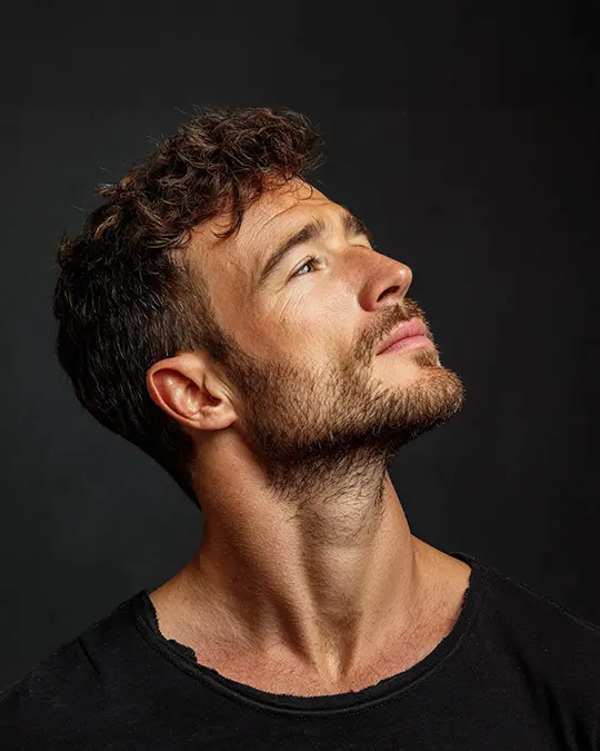 En brunett man med högt självförtroende efter herrklippning och skäggtrimning.