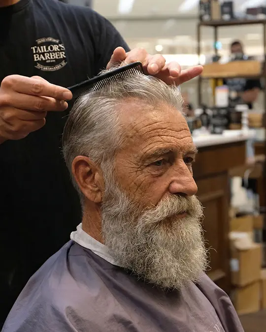 Seniorklippning för äldre man med skägg, hår och skägg anpassade för 65+ i modern barbershop.